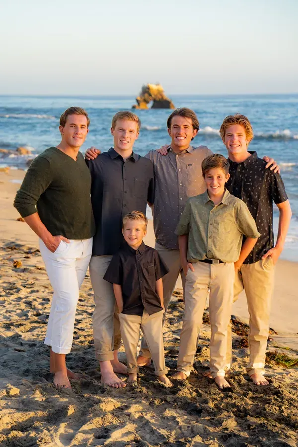 6 brothers are posing for a picture on the beach.