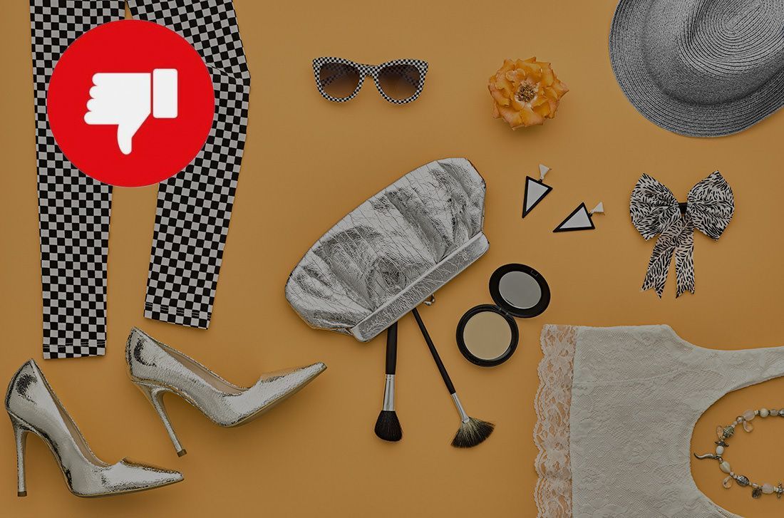 A woman 's clothes and accessories are laid out on a table with a thumbs down sign.