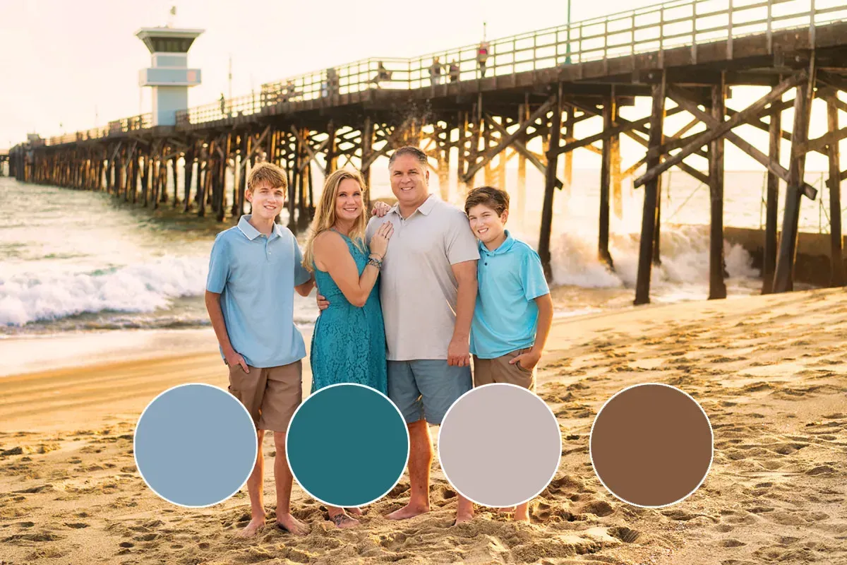 Seal Beach Pier Family Photo A family is posing for a picture on the beach in front of a pier.