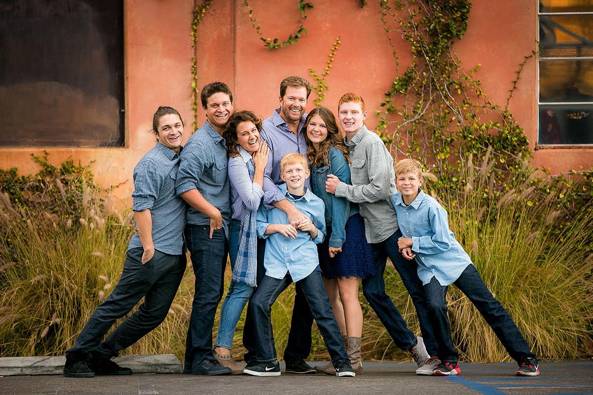 A large family is posing for a picture in front of a building.