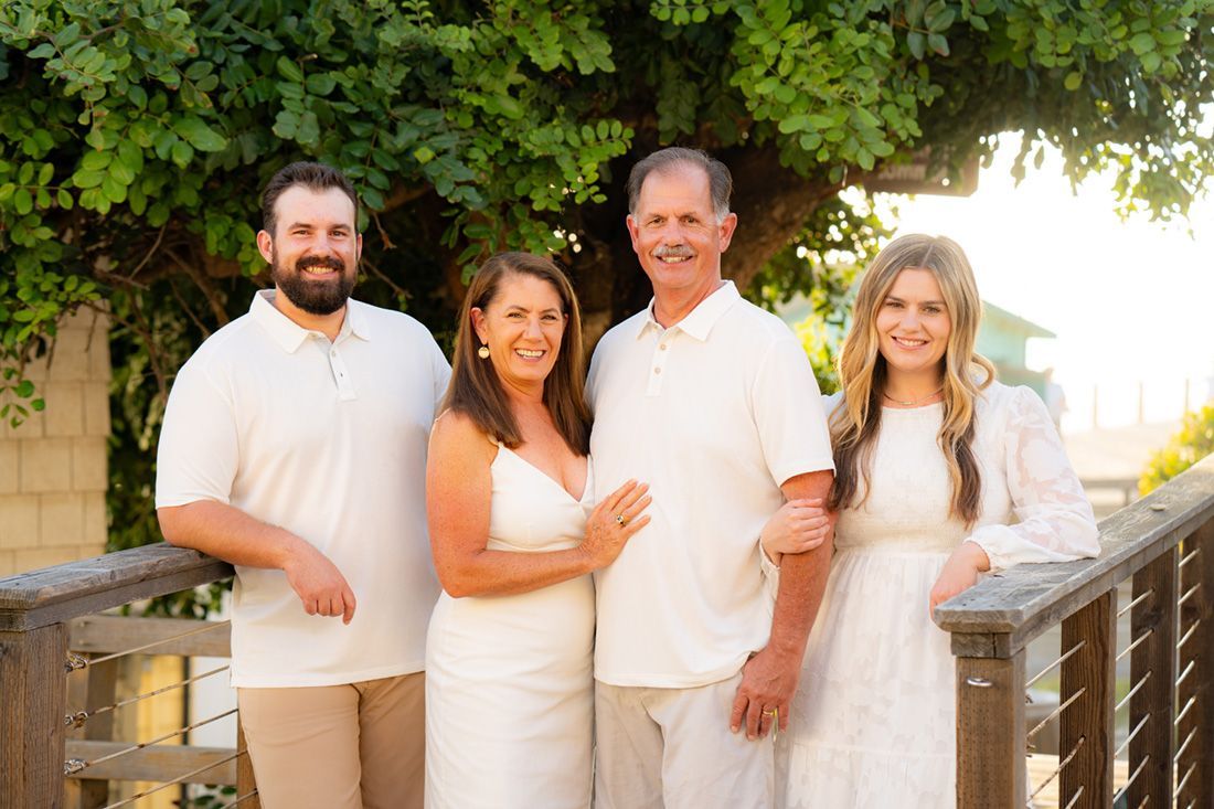 A family is posing for a picture on a bridge.
