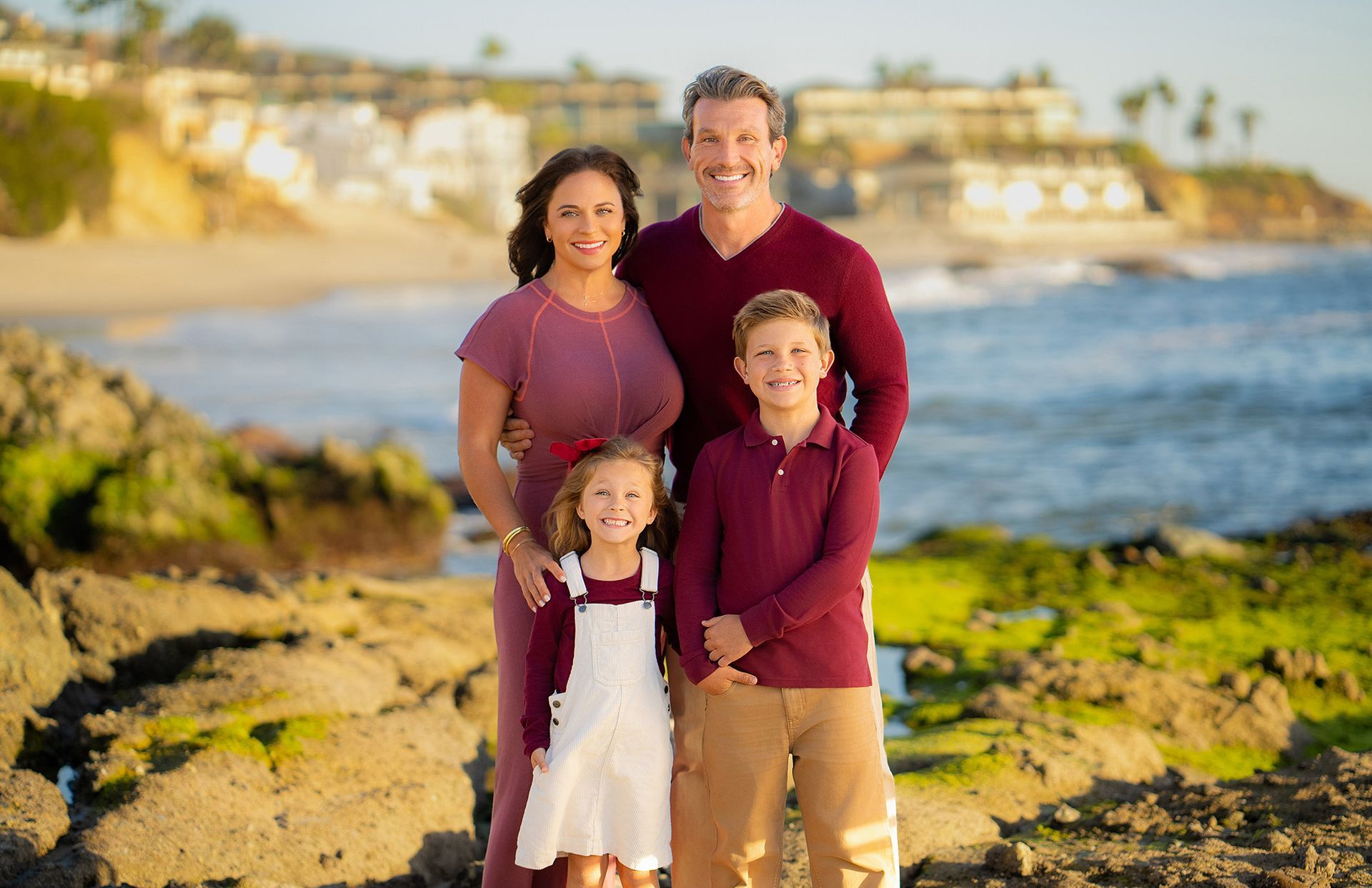 A family is posing for a picture on the beach.