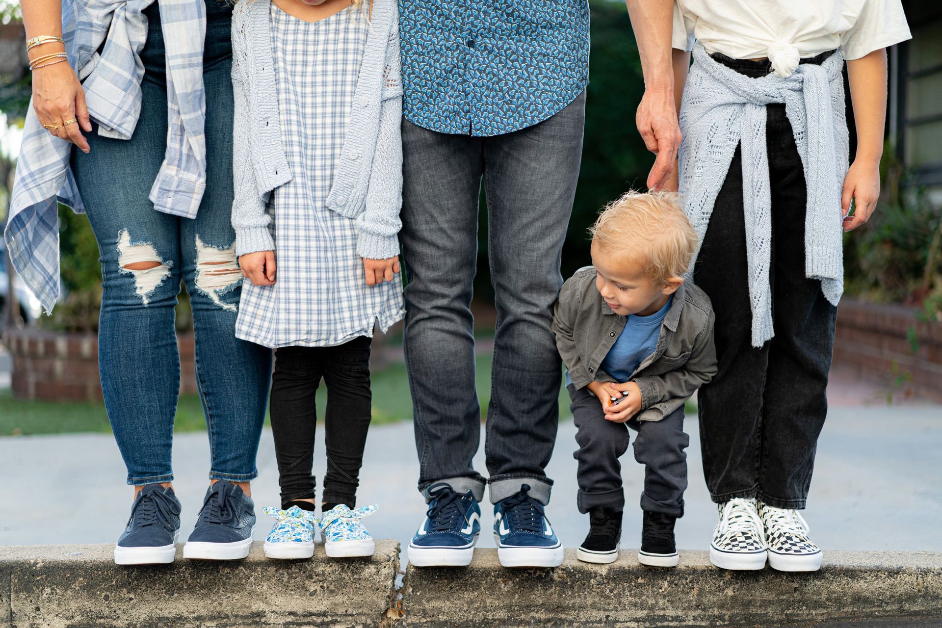 Orange County Family Photo A family is standing beside each other on a sidewalk wearing Vans shoes.