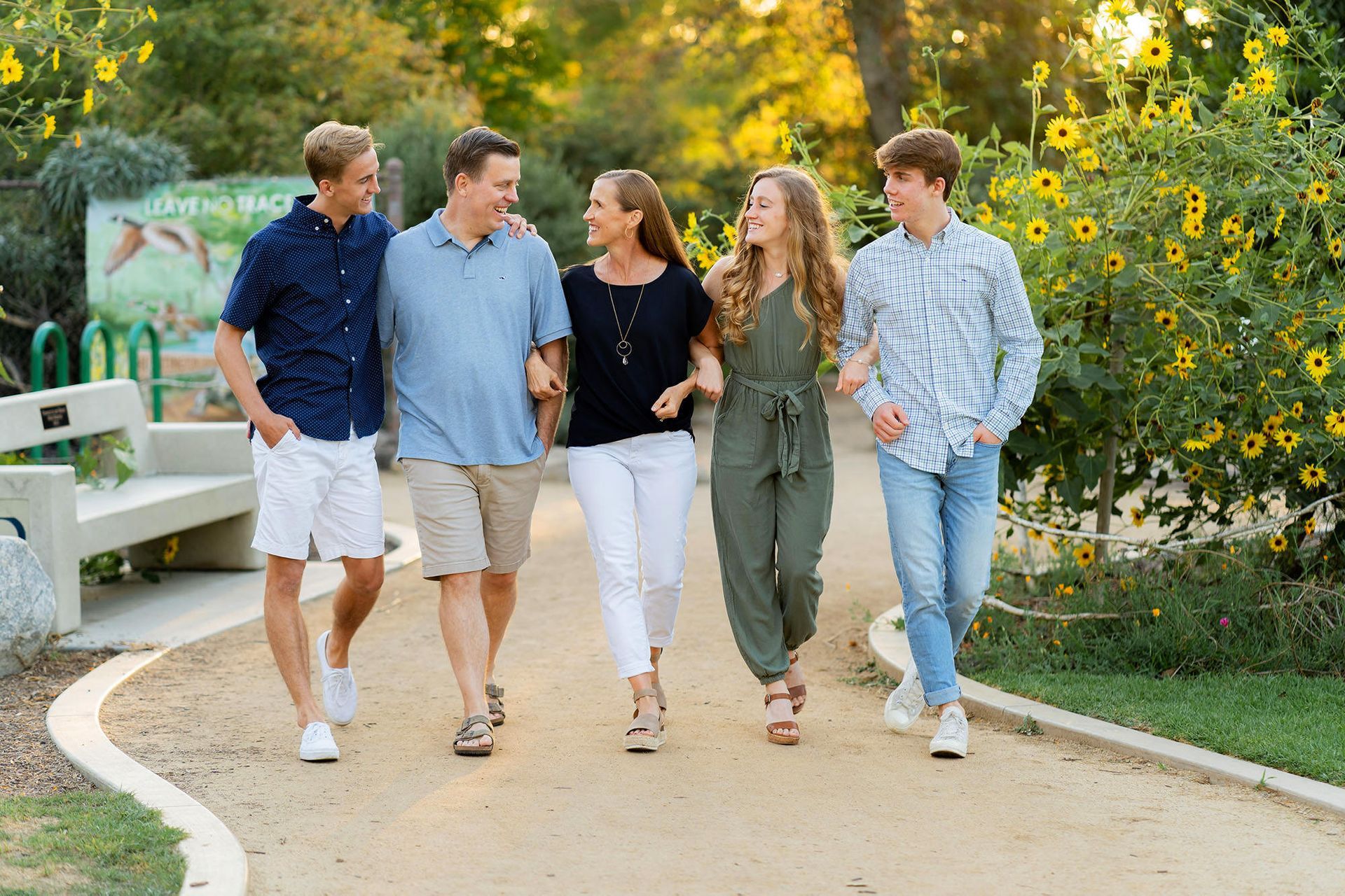 A family is walking down a path in a park.