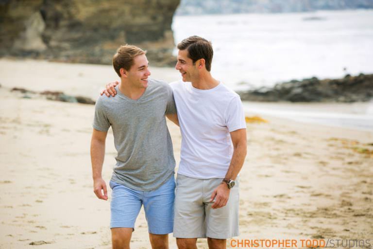 Laguna Beach Family Portrait Father and son are walking on the beach with their arms around each other.