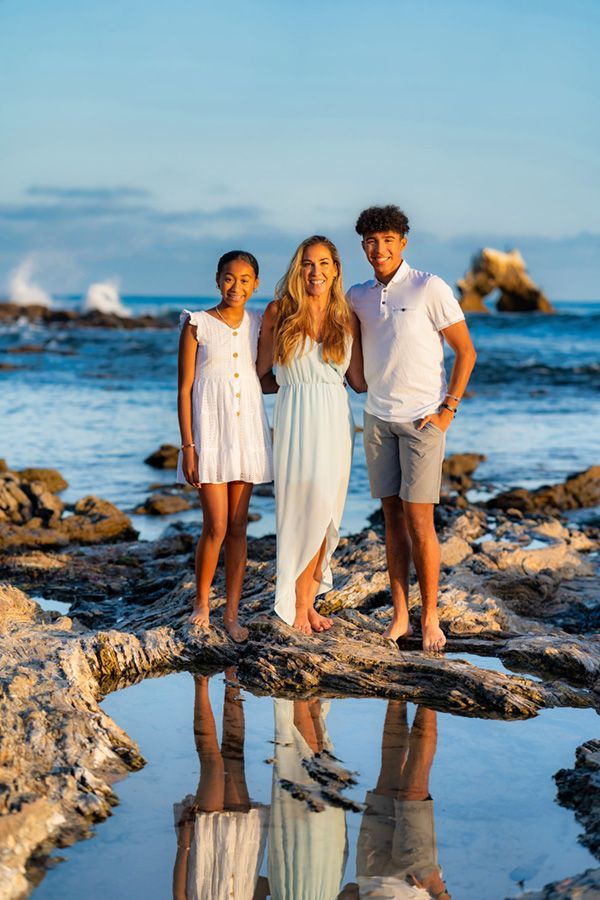 A family is posing for a picture on the beach.