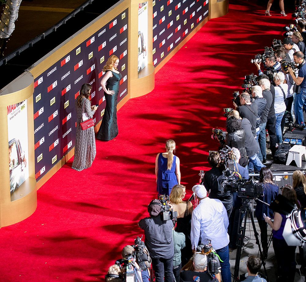 A group of people are standing on a red carpet