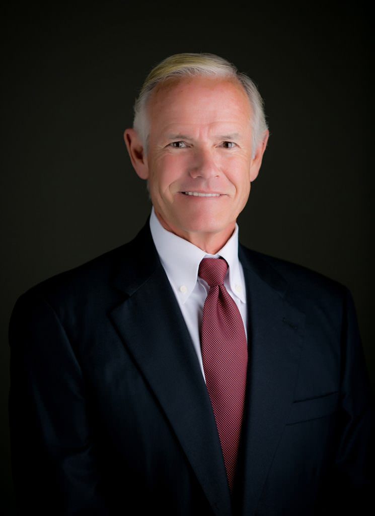 A man in a suit and tie is smiling for the camera.