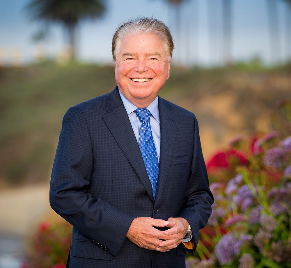 A man in a suit and tie is smiling for the camera