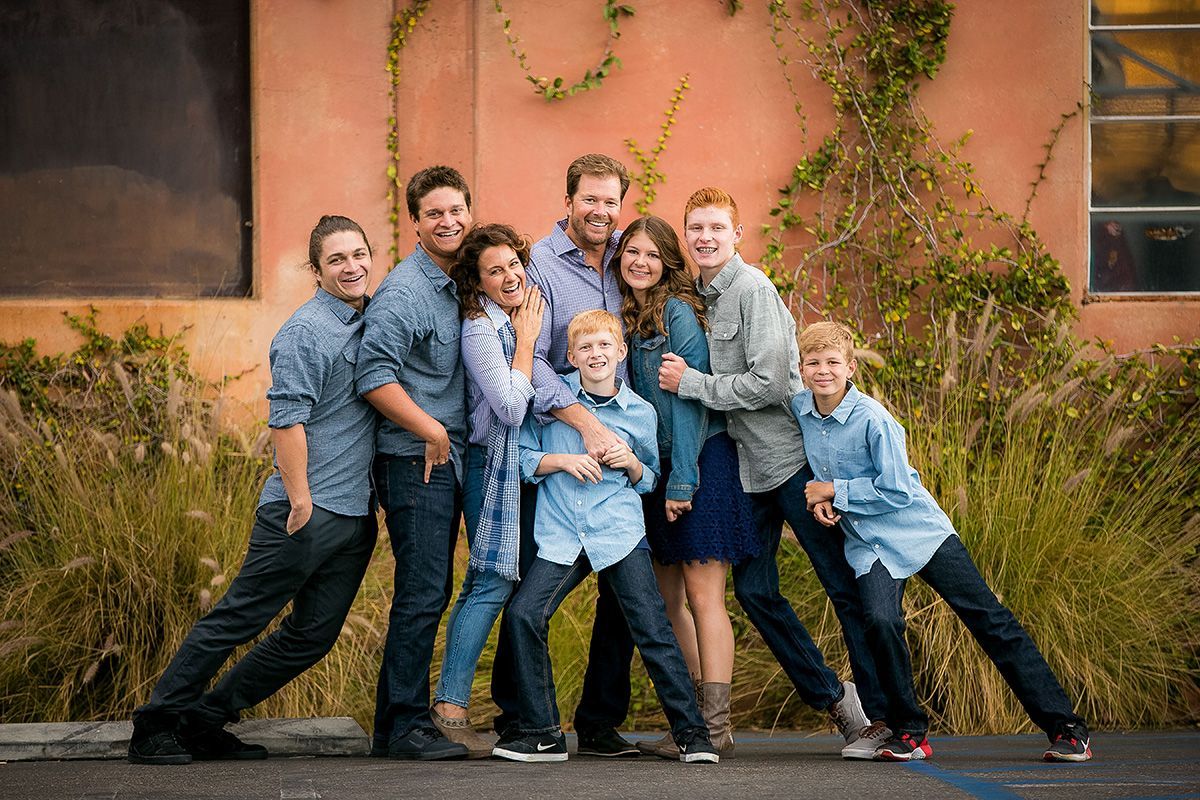 A large family is posing for a picture in front of a building