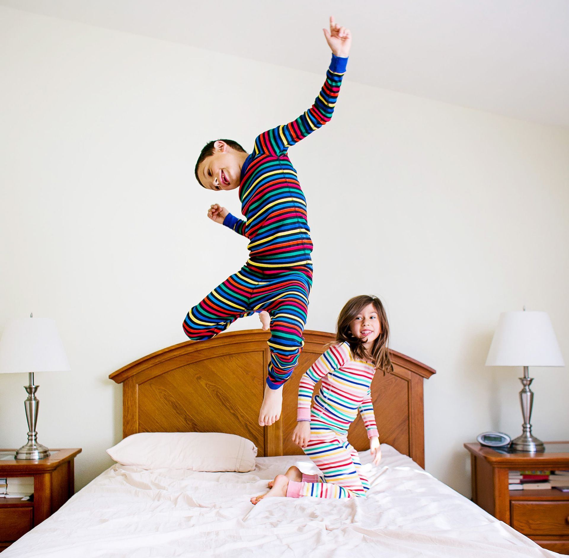 Lifestyle Photo Shoot A boy and a girl are jumping on a bed