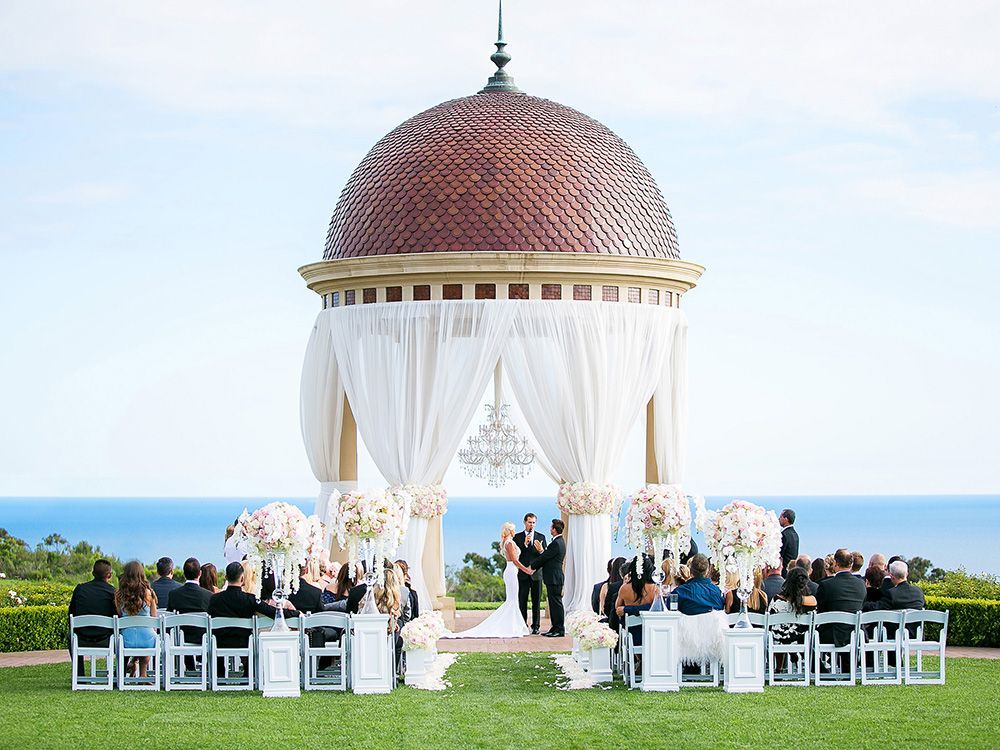 Orange County Wedding Photographer A wedding ceremony is taking place in Orange County under a dome with a view of the ocean.
