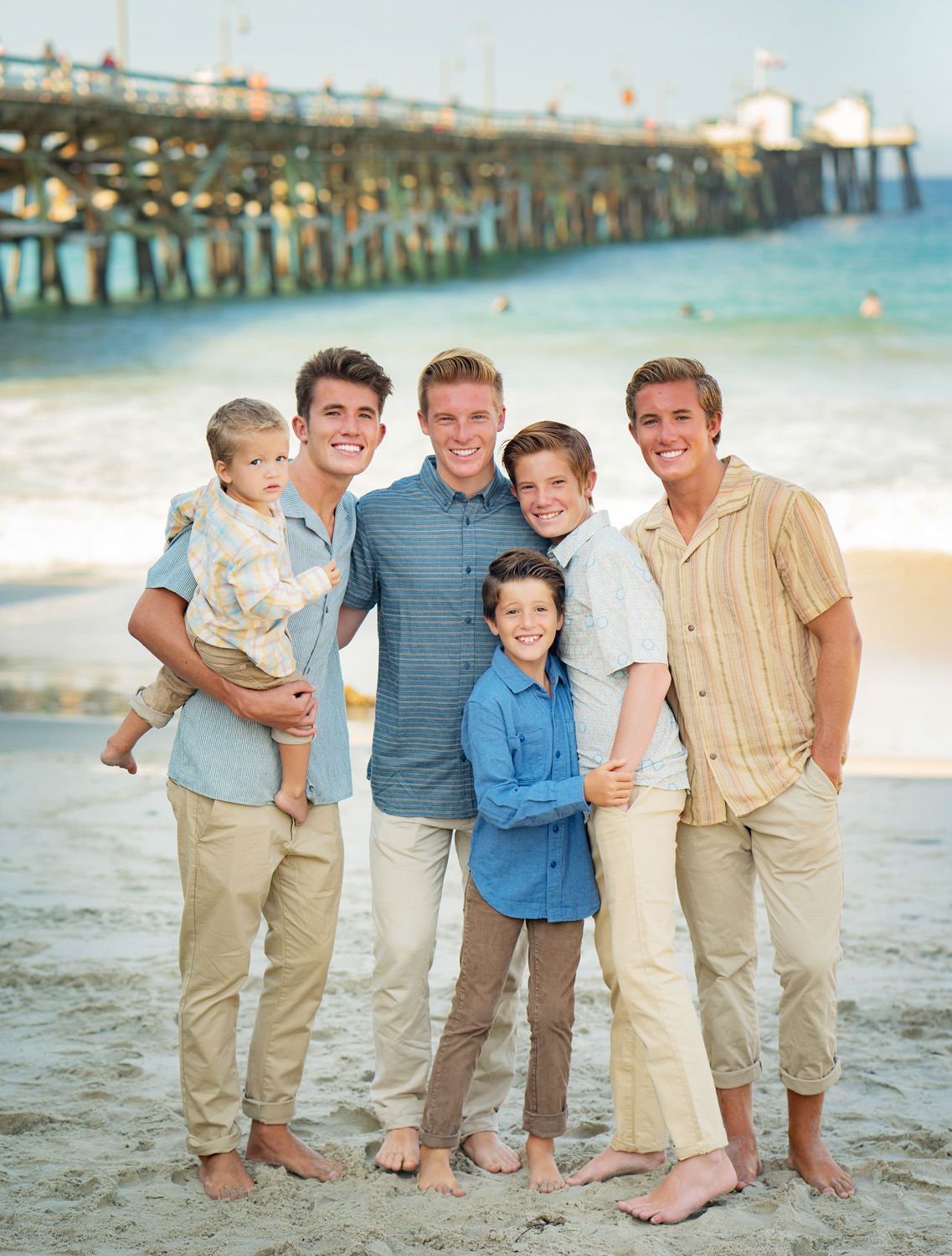 Beach Family Portraits A group of brothers are posing for a picture on the beach.