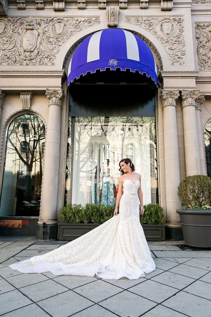 A Bride in a wedding dress is standing in front of the Beverly Wilshire Hotel 