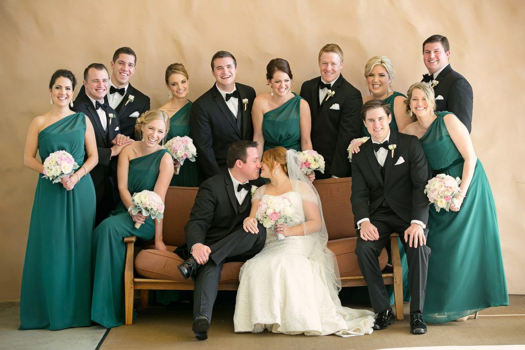 A bride and groom are posing for a picture with their wedding party at the spa courtyard at the Hyatt Huntington Beach.
