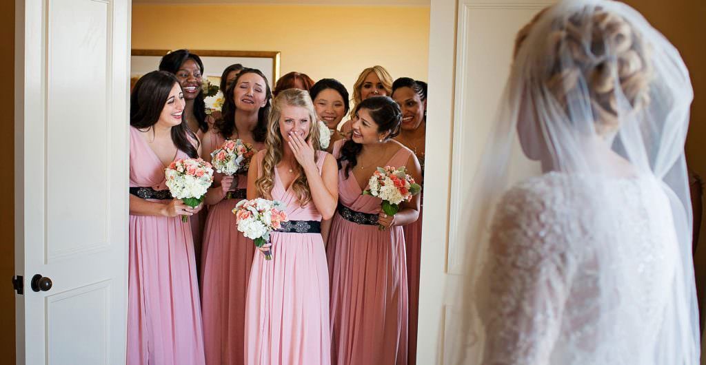 A bride and her bridesmaids are standing in a doorway.