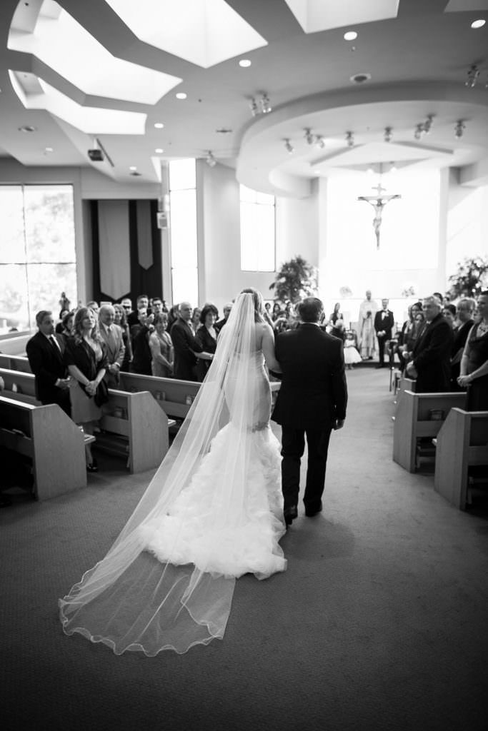 A bride and groom are walking down the aisle of a church.