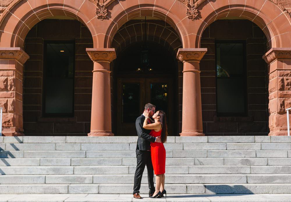 A bride and groom are kissing at the old courthouse Santa ana