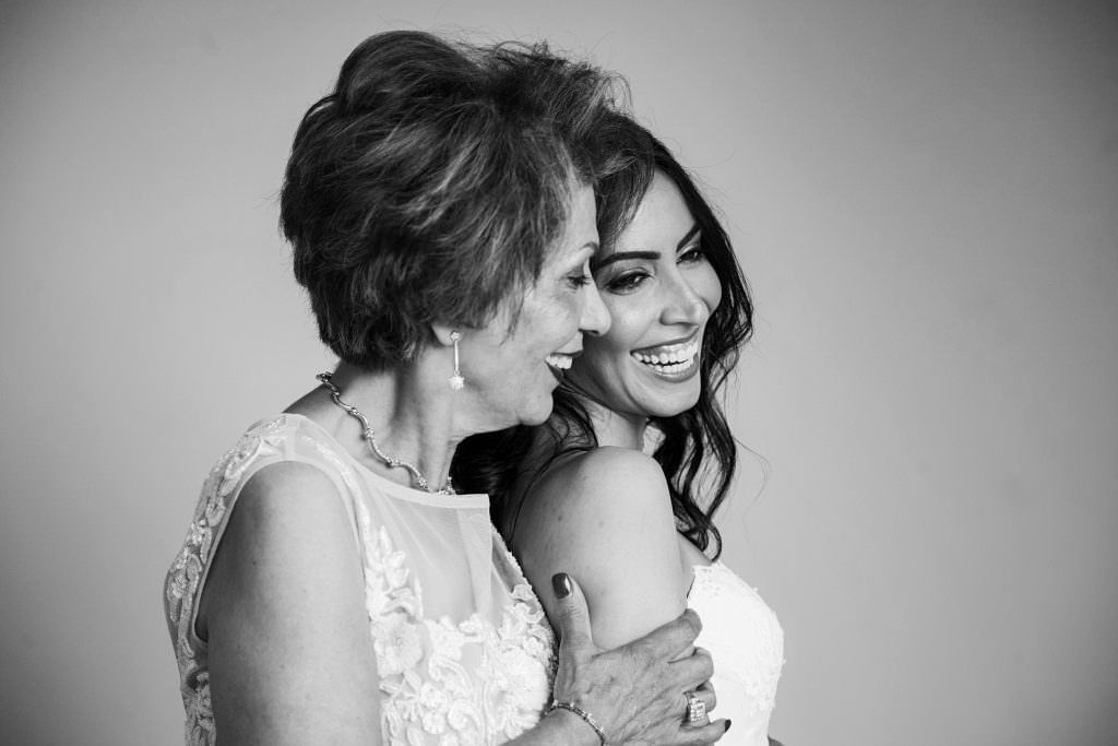 A mother and daughter are hugging each other in a black and white photo.