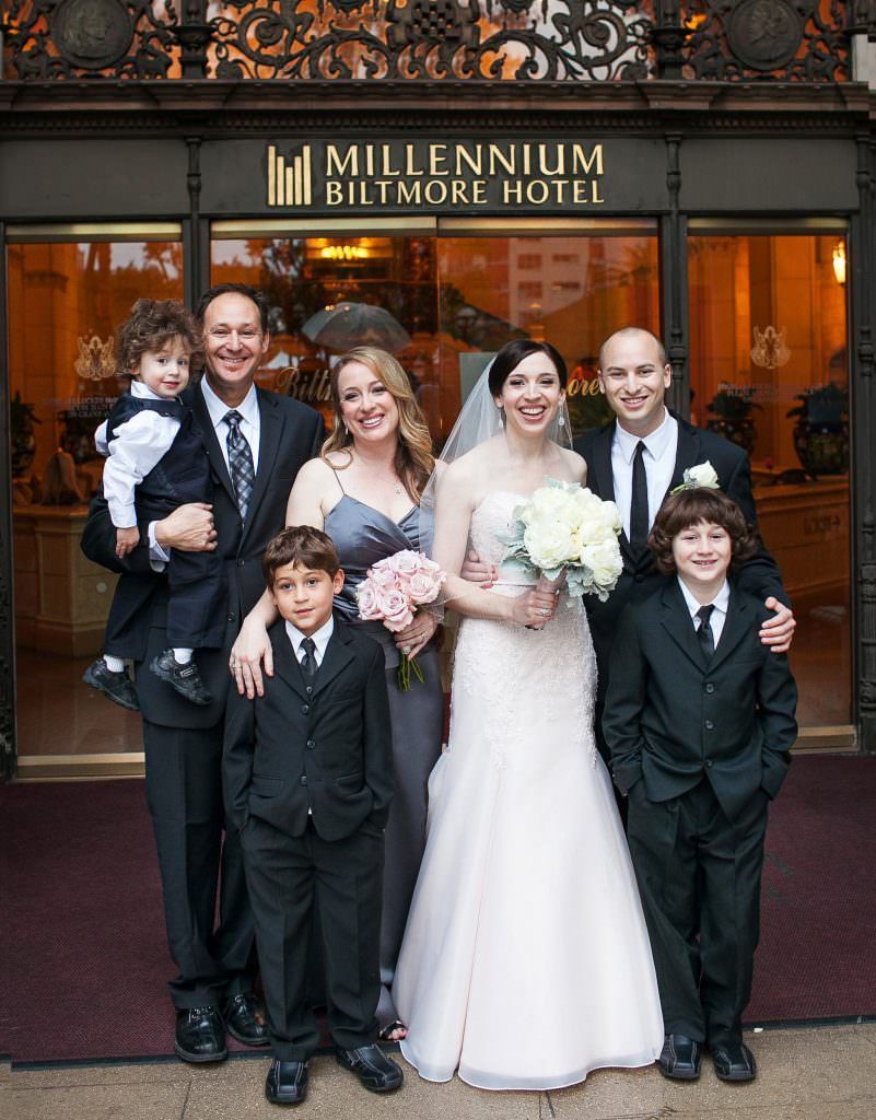 A group of people posing for a picture in front of the millennium biltmore hotel