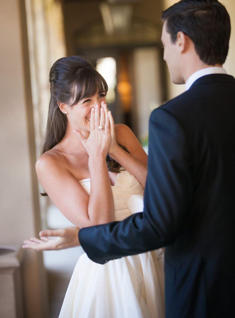 A bride and groom's first look laughing together before their wedding