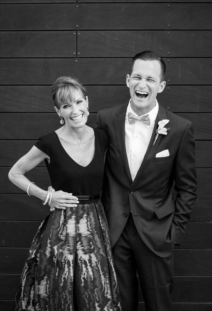 A black and white photo of a mom and groom posing for a picture.