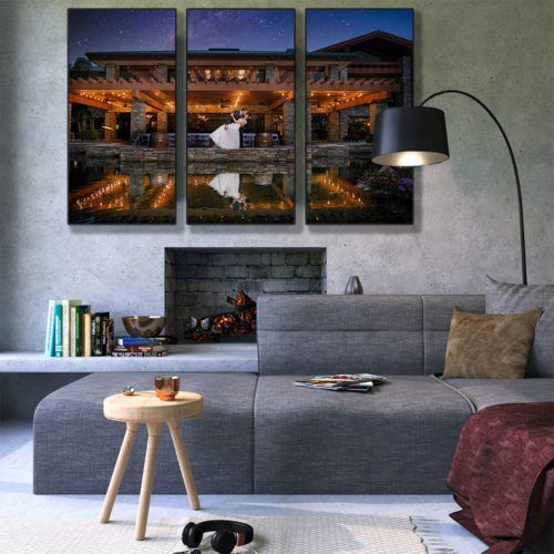 A living room with wedding photos on the wall and a couch and a lamp