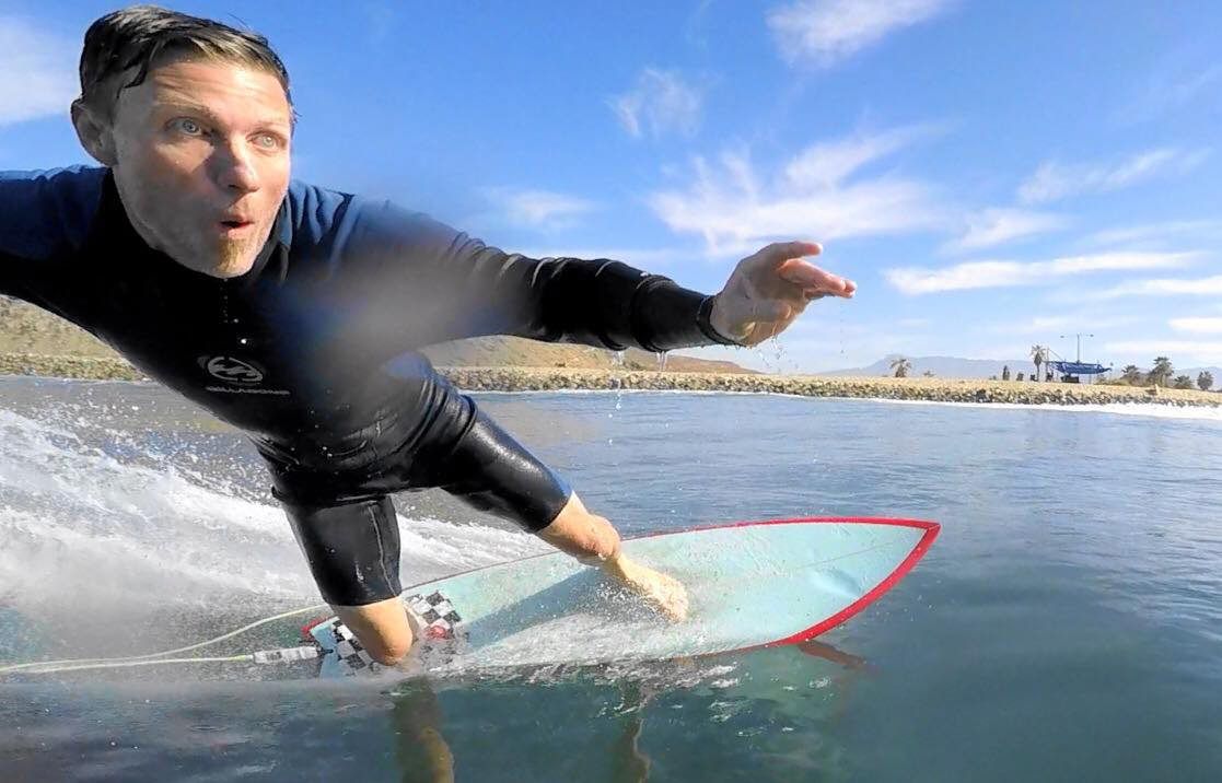 Christopher Todd is riding a wave on a surfboard in the ocean.