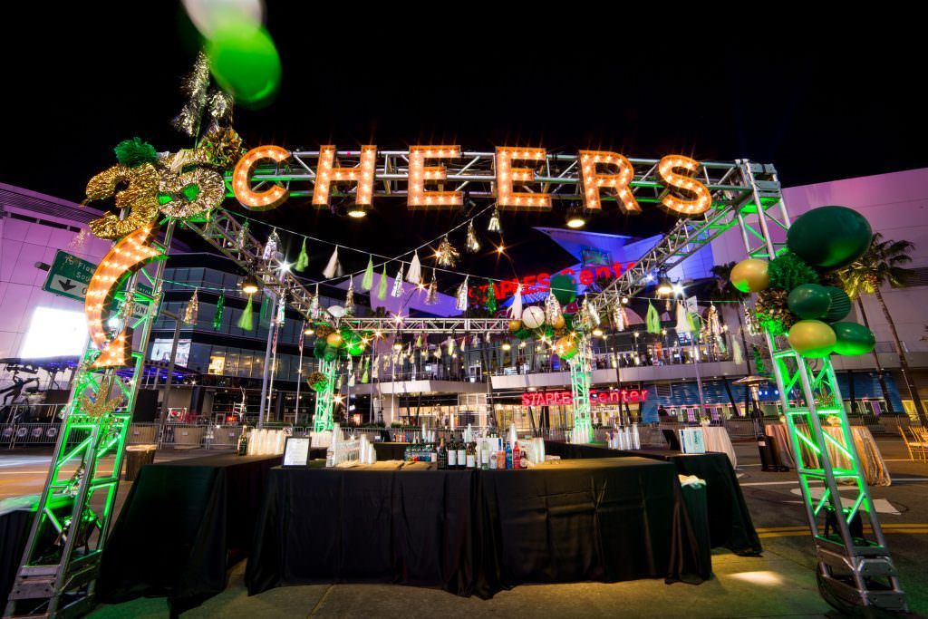 A cheers sign is hanging over a bar at a corporate event