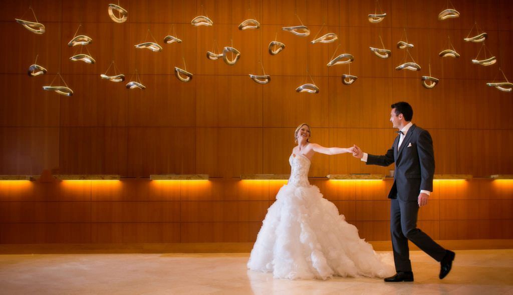 A bride and groom are dancing in a room.