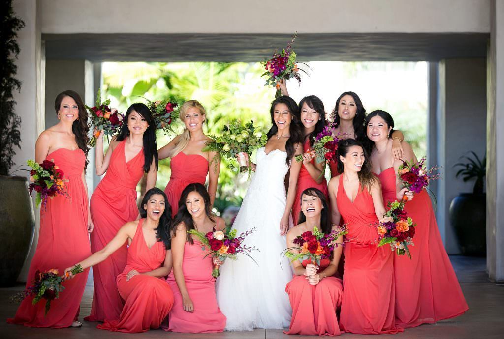 A bride and her bridesmaids are posing for a picture in Huntington Beach .