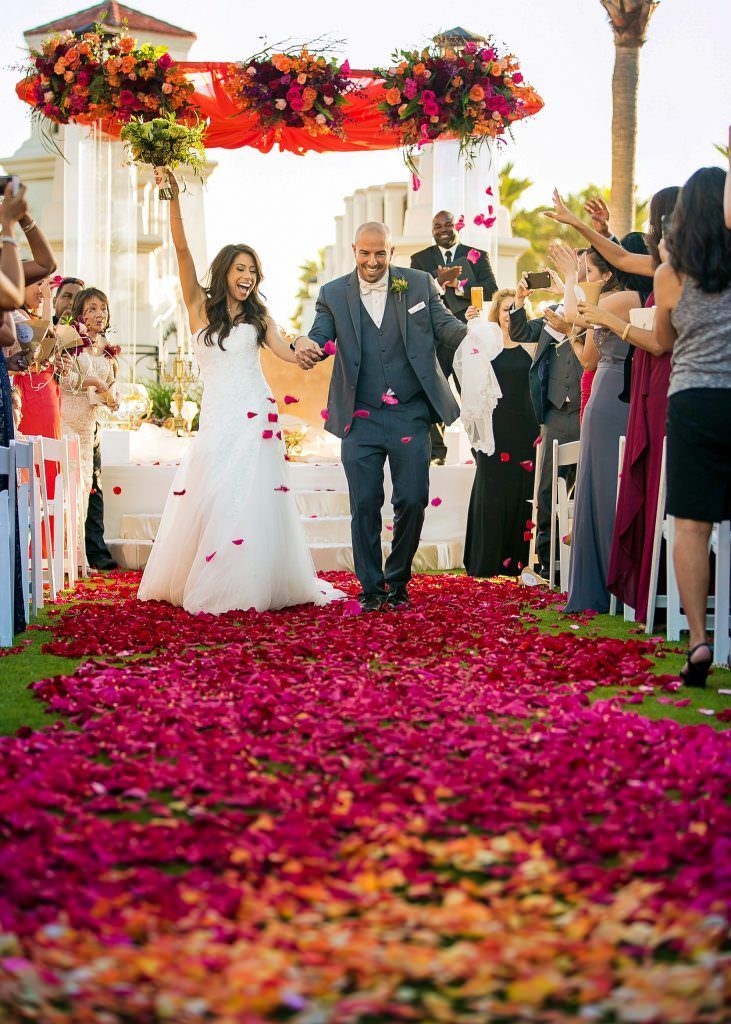 A bride and groom are walking down the aisle at their wedding.