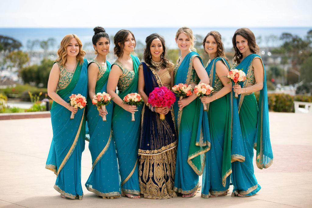 A bride and her bridesmaids are posing for a picture overlooking Newport Harbor