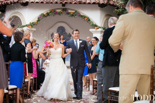 A bride and groom are walking down the aisle at their Rancho Las Lomas wedding