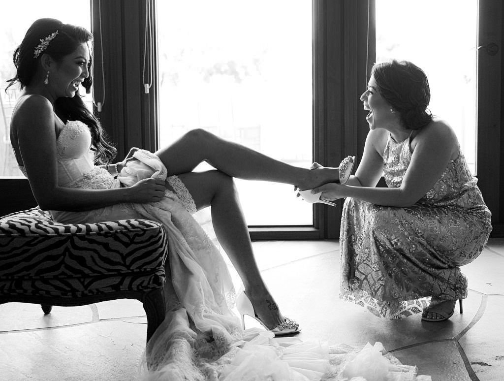 A black and white photo of a bride getting ready for her wedding