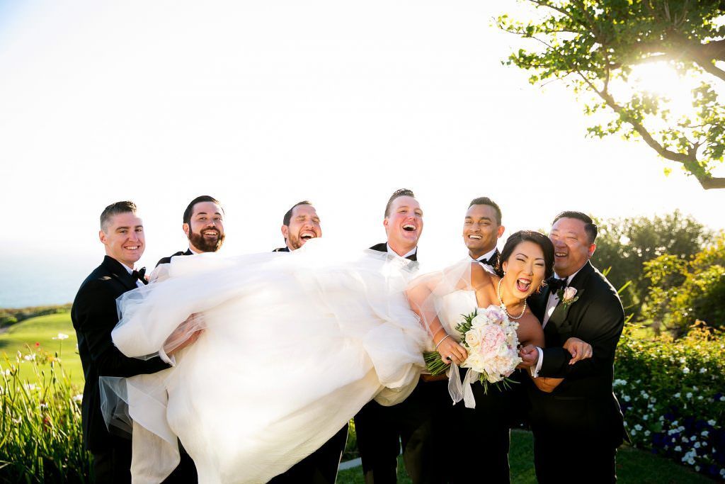 A group of men are holding a bride in their arms in Palos Verdes.