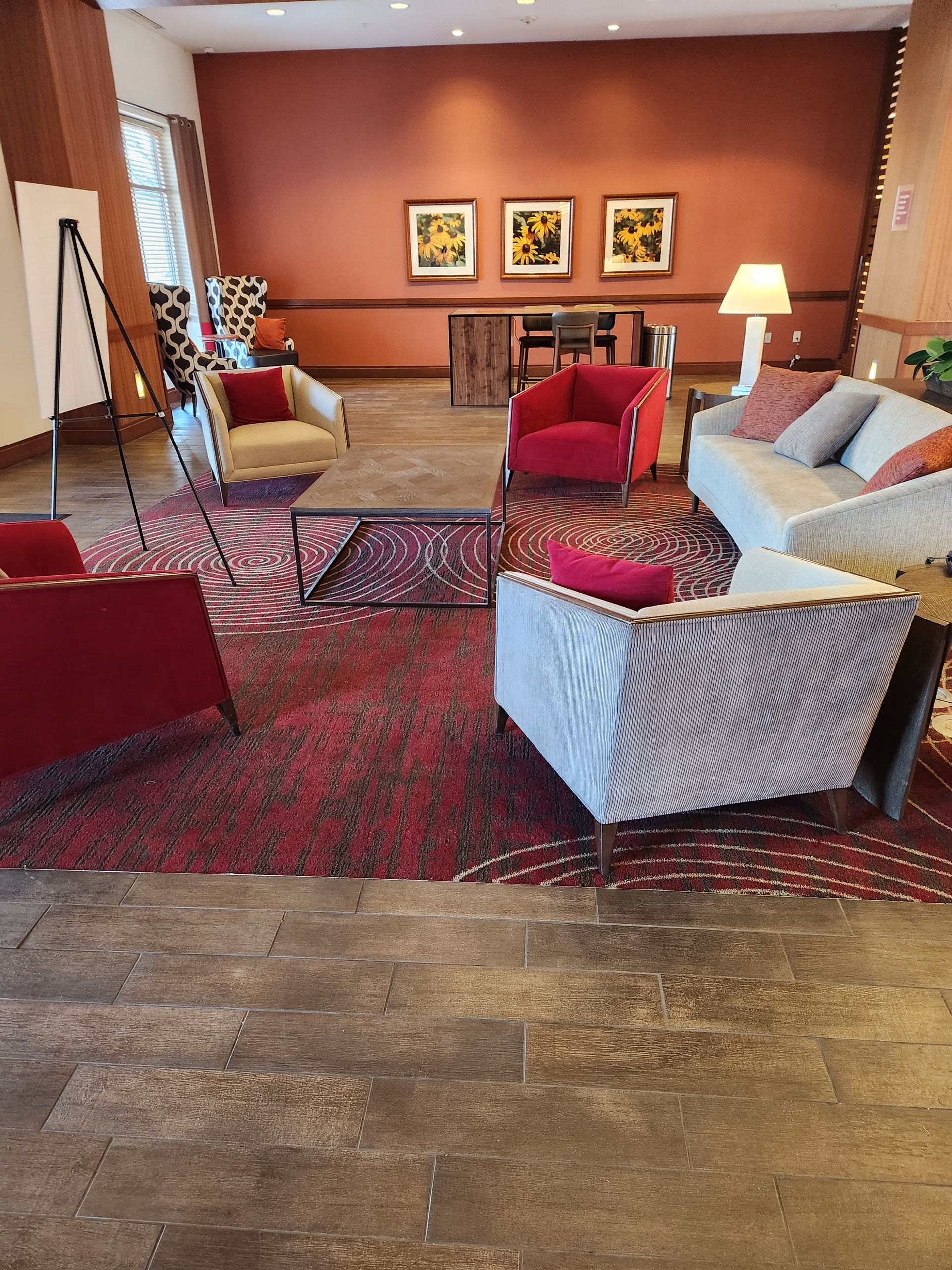 Modern office interior with workstations, large windows with cityscape view, and a wall garden.