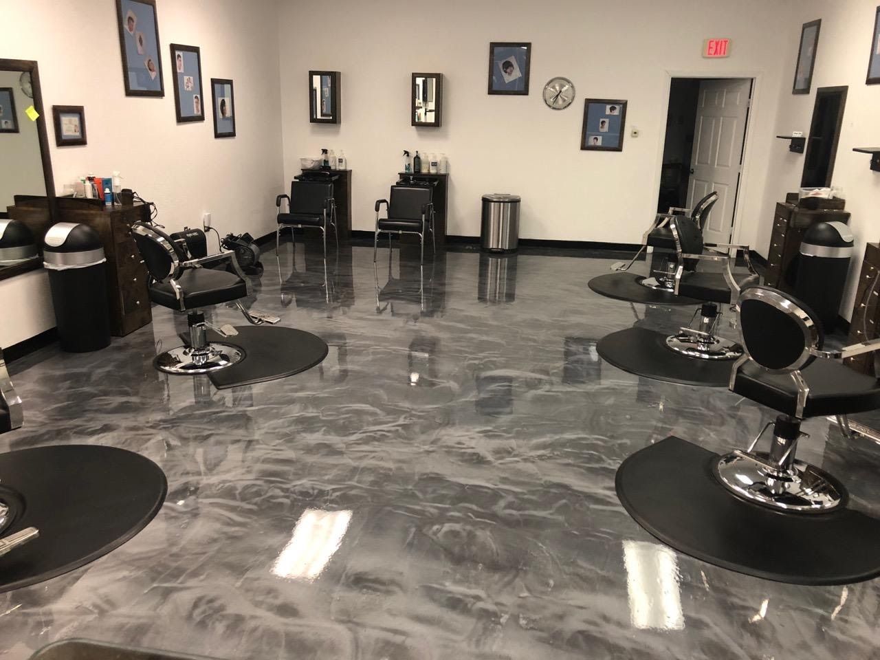 Person wearing yellow gloves spraying cleaner onto a blue cloth, wiping a white surface.