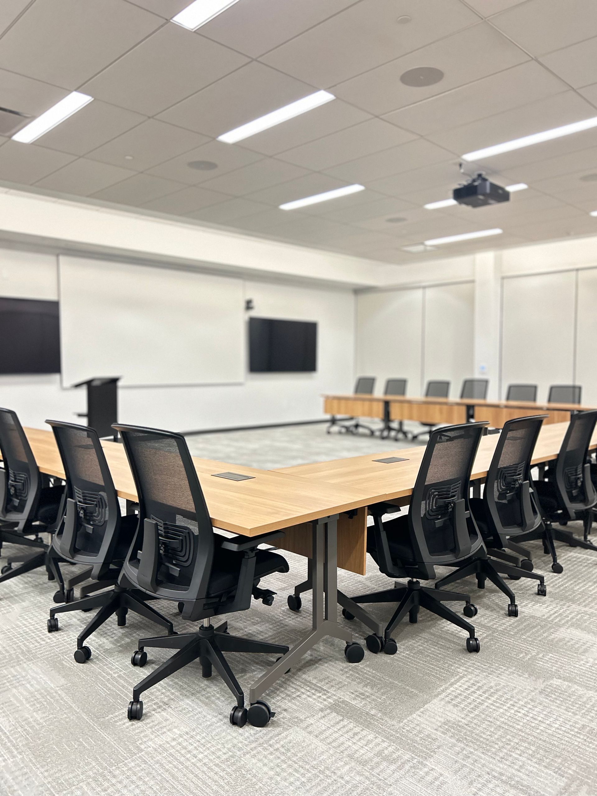 People cleaning an office space. One vacuums, another mops, and a third dusts stairs.