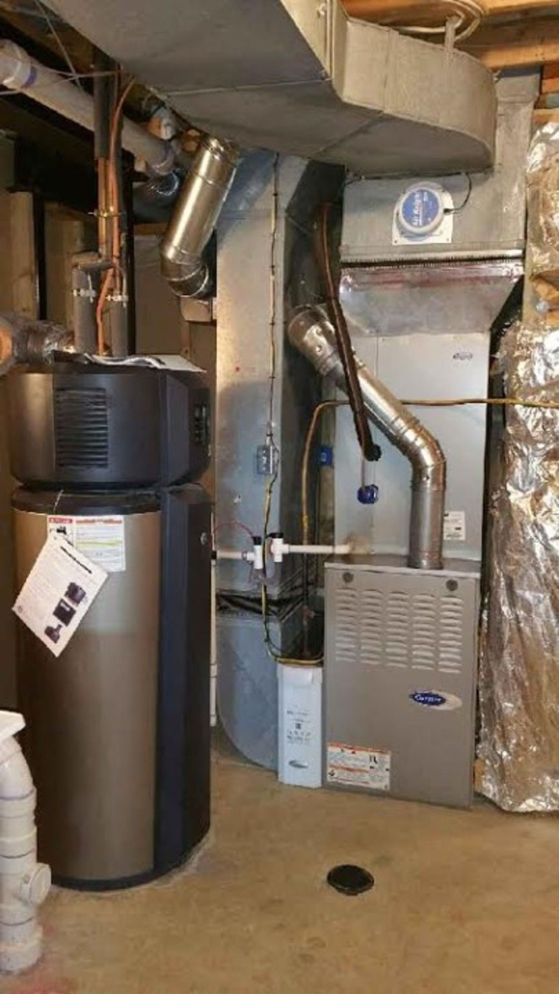 A basement with a furnace , water heater , and air conditioner.