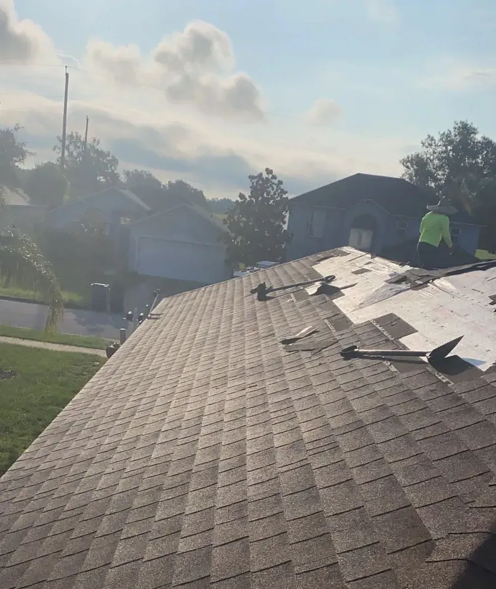 A man is working on the roof of a house.