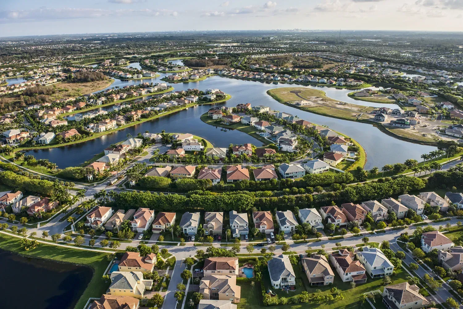 An aerial view of a residential area surrounded by water and houses.