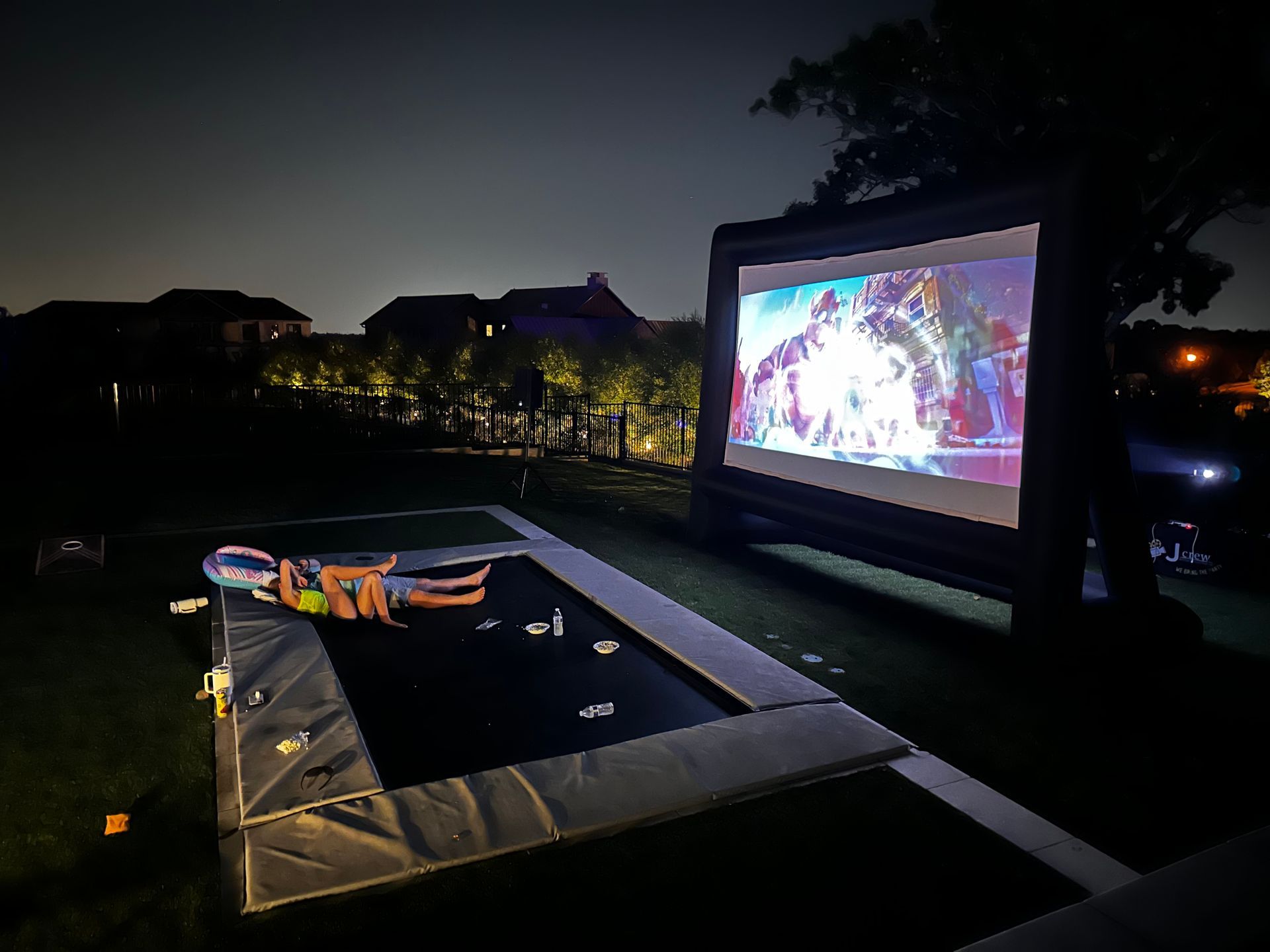 A group of people are watching a soccer game on a large screen.