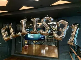 A bunch of silver balloons in the shape of the word ellie.