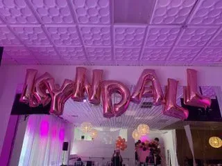 A room decorated with pink balloons that spell out the name kendall.