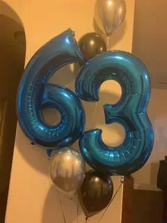 A bunch of blue balloons with the number 63 on them.