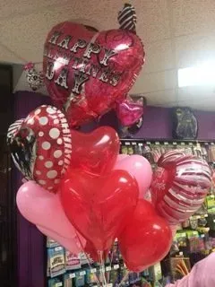 Two green margaritas with limes on a wooden cutting board.