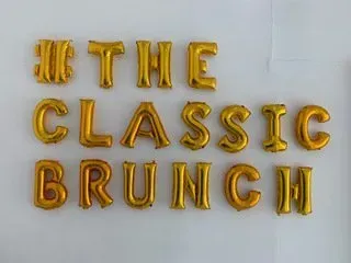 A bunch of gold balloons that say the classic brunch