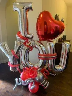 A bunch of balloons shaped like the word i love you.