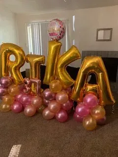 A bunch of balloons are sitting on the floor in a room.
